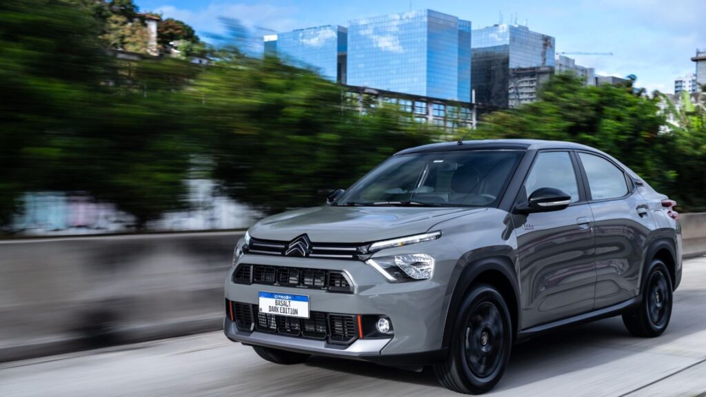 Citroën Basalt 2026 Dark Edition cinza em movimento na estrada com árvores no fundo.