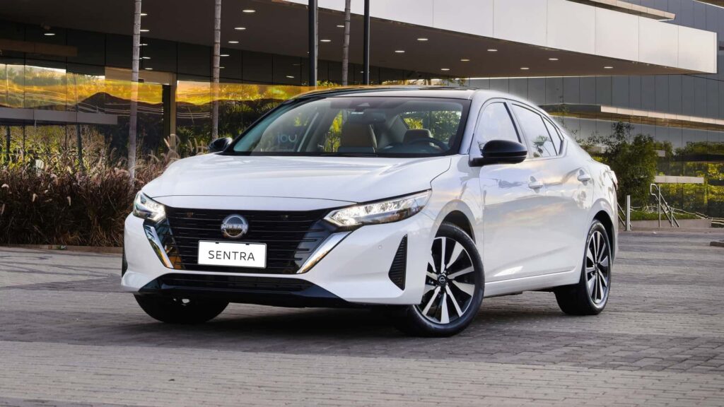Nissan Sentra branco parado na diagonal.