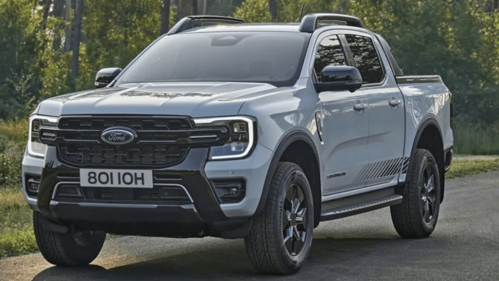 Ford Ranger cinza parado com os faróis ligados.