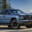 Mitsubishi Triton Tarmac azul parada na diagonal no meio da estrada.