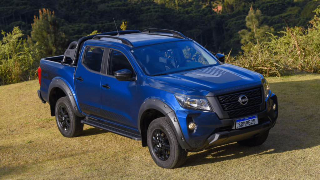 Nissan Frontier 2026 azul parada na diagonal em cima de um gramado.