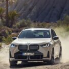 Novo BMW X3 bege acelerando na estrada.