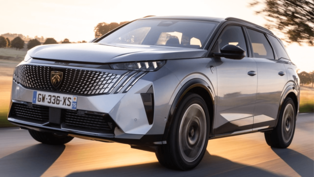 Peugeot 5008 prata em movimento na estrada com o sol no fundo.