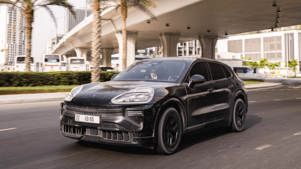 Novo Porsche Cayenne elétrico preto andando no asflato.