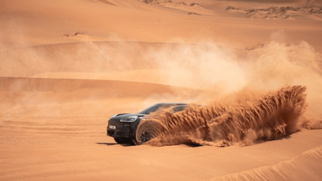Novo Porsche Cayenne elétrico acelerando na areia e jogando ela pro ar.