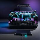 Carro colorido de frente com um carregador na sua frente.