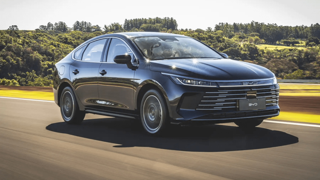 BYD King 2026 azul em movimento na estrada com um sol de rachar.