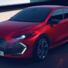 Novo Renault Clio 2026 vermelho parado na diagonal em uma sombra com os faeóis acesos.
