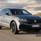 Volkswagen Touareg cinza de frente com um céu cheio de nuvens no fundo,