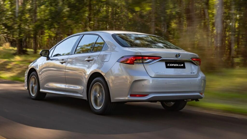 Traseira do Toyota Corolla 2026 prata em movimento em um asfalto.
