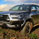 Toyota Hilux cinza parado na diagonal em um barro.