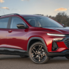 Chevrolet Tracker 2026 vermelho parado na diagonal com os faróis acesos.