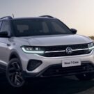 Volkswagen T-cross branco parado na diagonal com os faróis acesos.