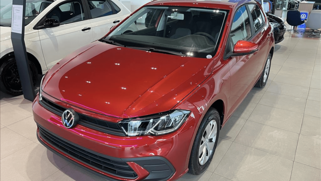Volkswagen Polo Sense vermelho parado dentro de uma concessionaria.