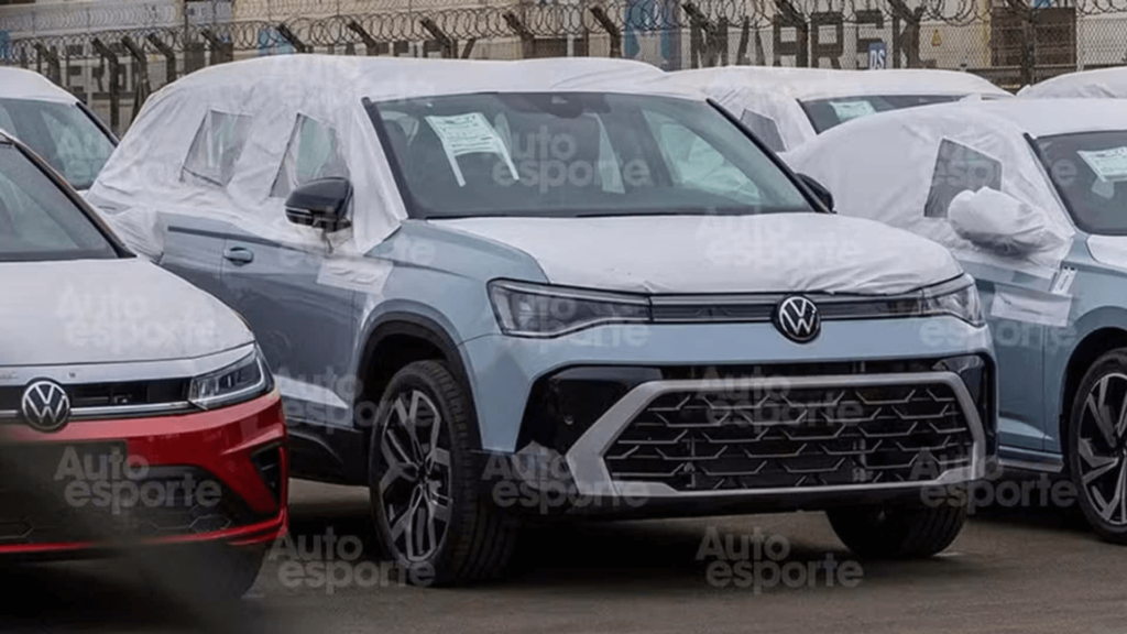 Taos 2026 azul estacionado no meio de vários carros.