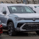 Taos 2026 azul estacionado no meio de vários carros.