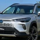 Corolla Cross Hybrid prata parado na diagonal de frente.