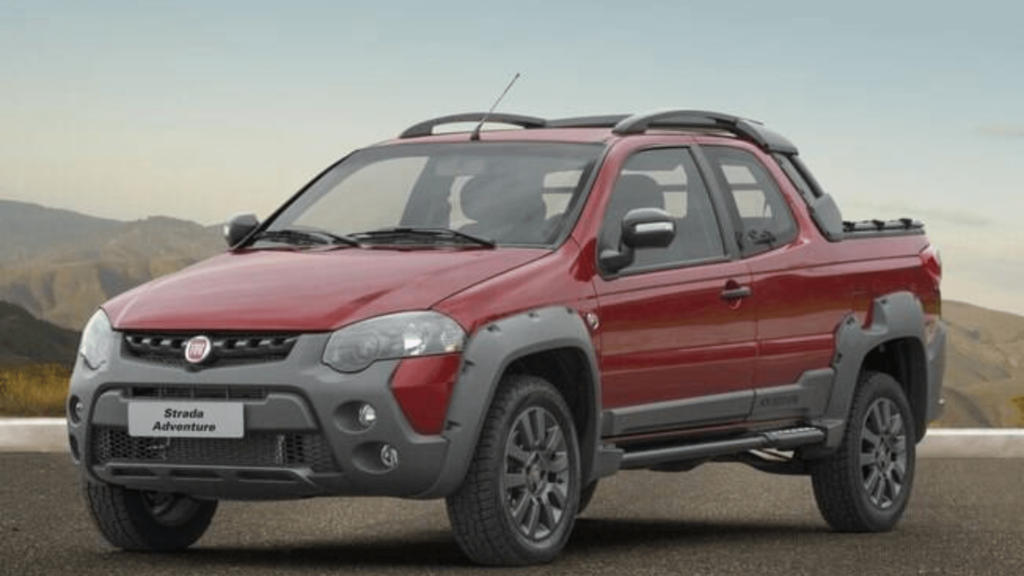 Fiat Strada vermelha parada no meio da estrada.