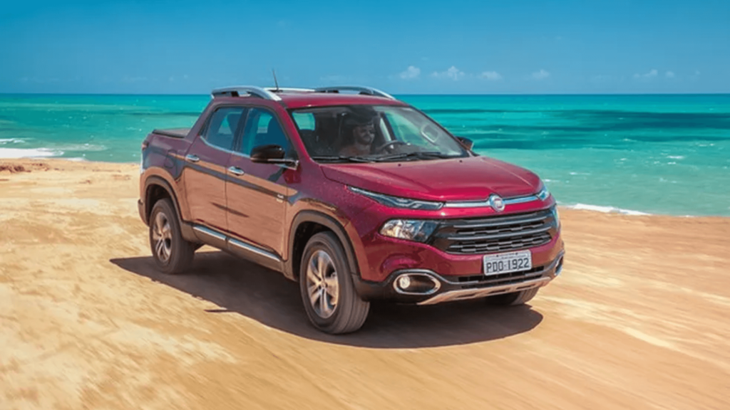Fiat Toro vermelho em movimento na estrada de barro.