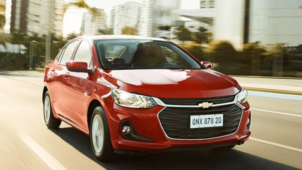Chevrolet Onix Plus vermelho em movimento na estrada.