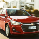 Chevrolet Onix Plus vermelho em movimento na estrada.