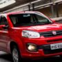 Fiat Uno vermelho em movimento na estrada.
