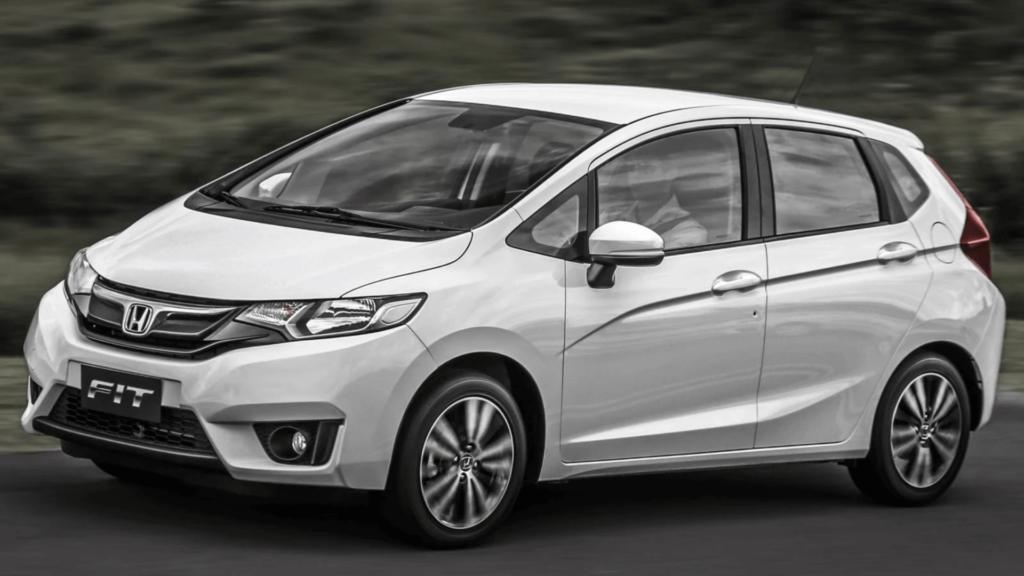 Honda Fit branco em movimento na estrada.