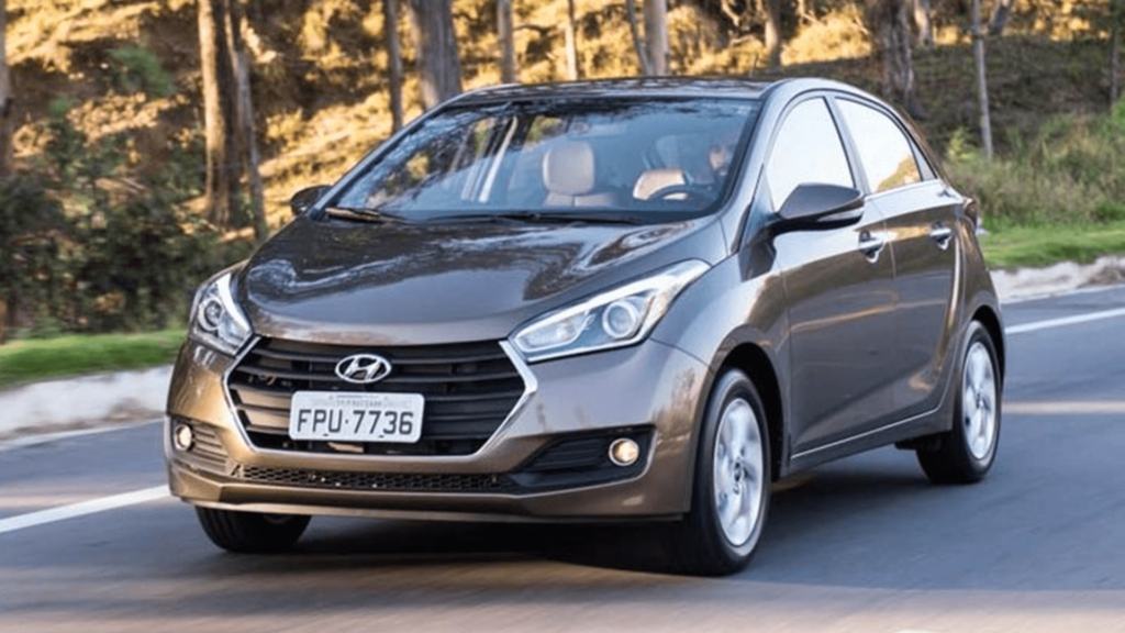 Hyundai HB20 marrom em movimento na estrada.