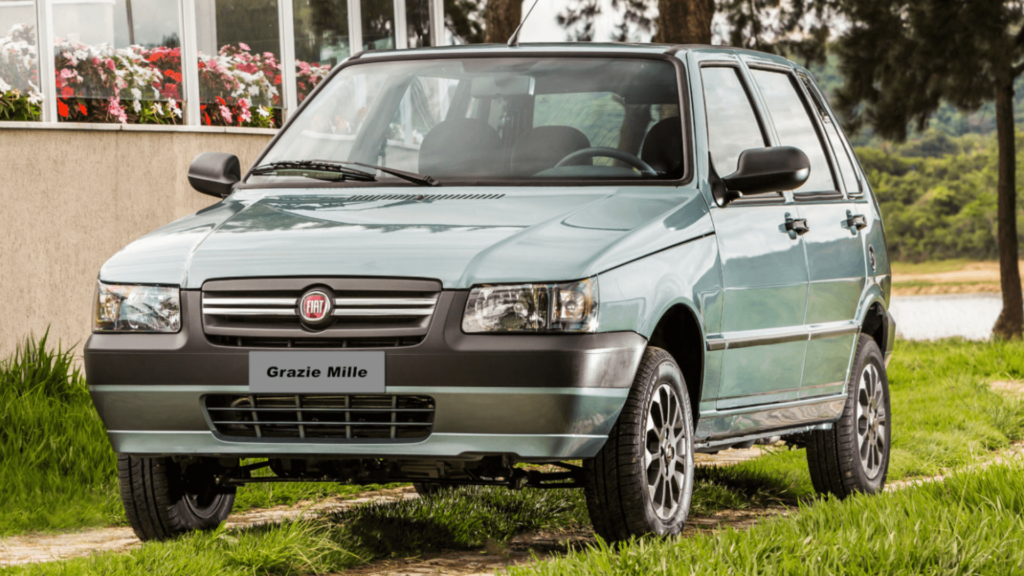 Fiat Uno cinza em movimento na estrada.