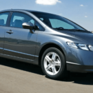 Honda Civic cinza em movimento na estrada.