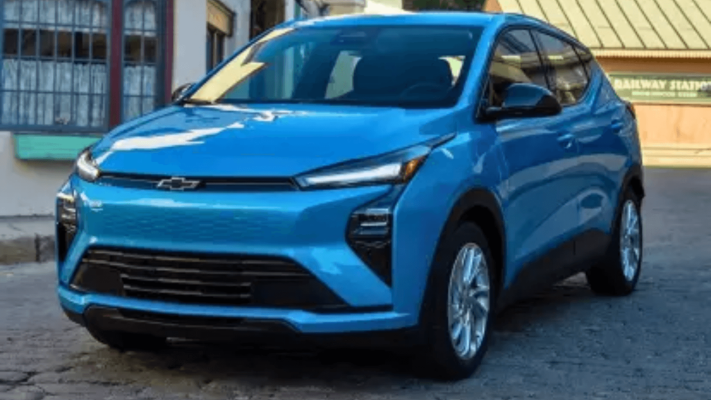 Chevrolet Bolt 2027 azul parado na diagonal com os faróis acesos.