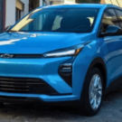 Chevrolet Bolt 2027 azul parado na diagonal com os faróis acesos.