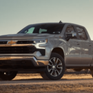 Chevrolet Silverado 2025 parado na diagonal no meio da estrada com uma cerca no fundo.