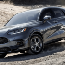 Honda ZR-V 2026 cinza parado na diagonal no meio da estrada de chão.