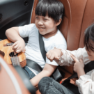 Duas crianças sentadas no banco de um carro.