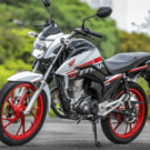 Honda CG 150 Titan branca parada na diagonal.