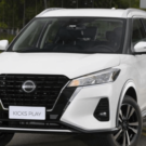 Nissan Kicks de 1ª geração branco parado na diagonal no meio da estrada.