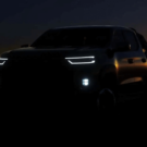 Ram Dakota 2026 preta parada na diagonal com os faróis acesas.