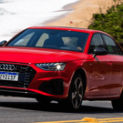 Audi A4 e-tron vermelho em movimento na estrada.