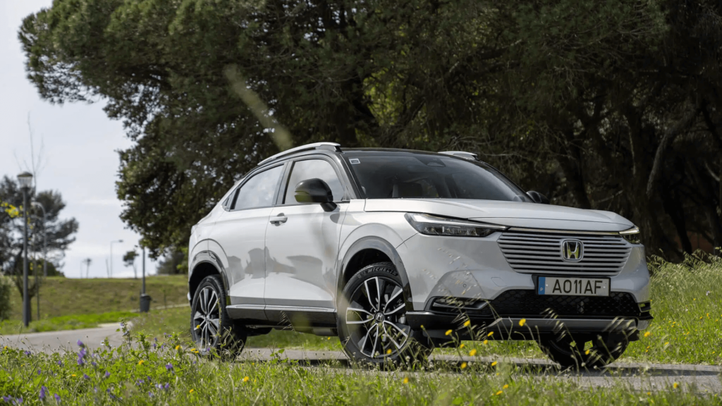 Novo Honda HR-V híbrido flex branco fazendo uma curva na estrada.