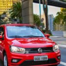 Frente do Volkswagen Gol vermelho com os faróis acesos.