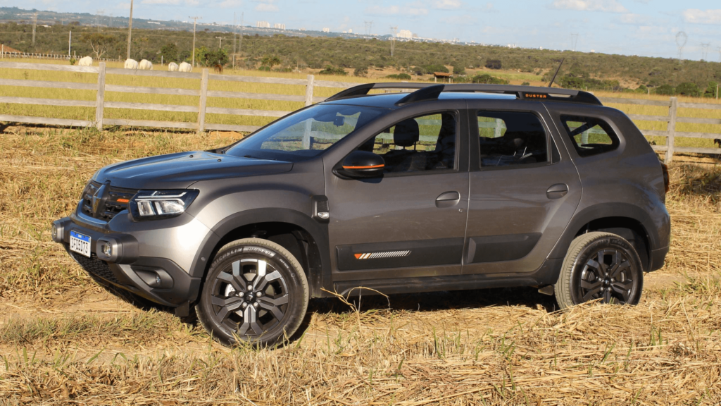 Renault Duster Iconic Plus 1.3 Turbo CVT cinza parada de lado em um gramado.