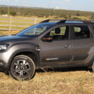 Renault Duster Iconic Plus 1.3 Turbo CVT cinza parada de lado em um gramado.