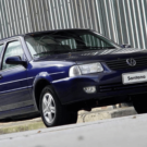 Volkswagen Santana azul parado na beirada na beirada da estrada.