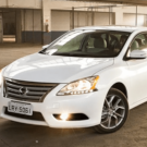 Nissan Sentra branco parado na diagonal.