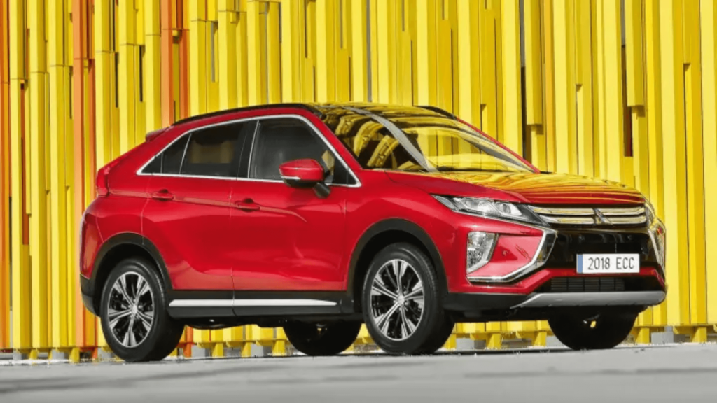 Mitsubishi Eclipse Cross vermelho parado na diagonal em um muro amarelo no fundo.