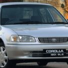 Toyota Corolla prata parado na diagonal.