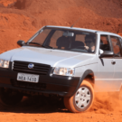 Fiat Uno Mille prata derrapando na areia.