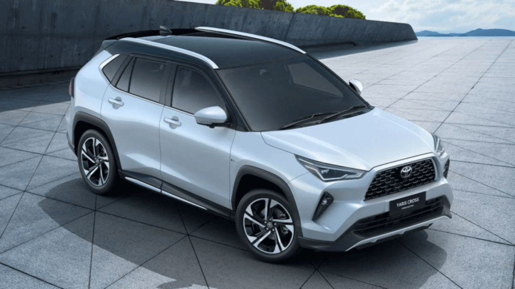 Toyota Yaris Cross prata parado na diagonal em um fundo cinza com os faróis apagados.