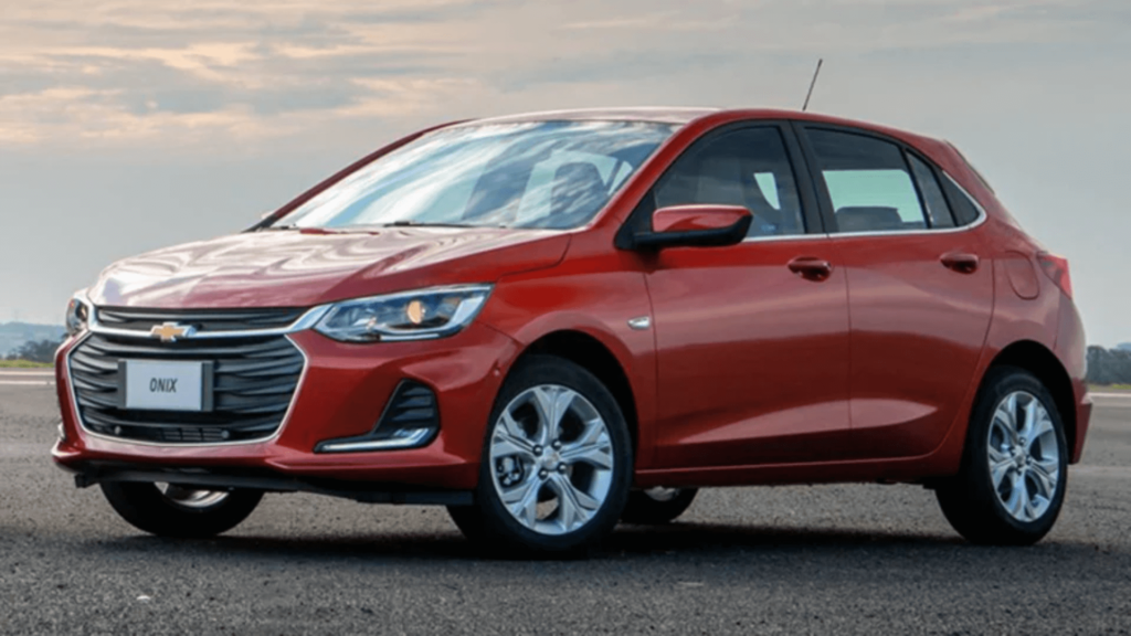 Chevrolet Onix vermelho parado na diagonal.